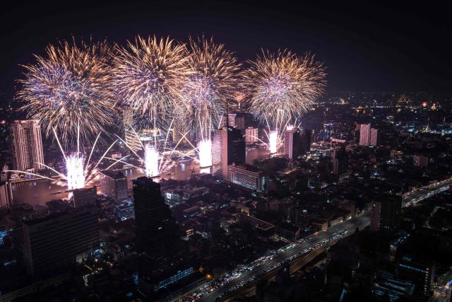 Fireworks light up the midnight sky over the Chao Phraya River during 2026 New Year's Day celebrations in Bangkok on January 1, 2026. (Photo by Chanakarn Laosarakham / AFP)