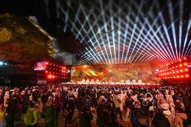 Dancers perform on stage as people celebrate the New Year 2026 at the Juyongguan Great Wall, Beijing, on January 1, 2026. (Photo by ADEK BERRY / AFP)