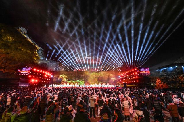 TOPSHOT - Dancers perform on stage as people celebrate the New Year 2026 at the Juyongguan Great Wall, Beijing, on January 1, 2026. (Photo by ADEK BERRY / AFP)