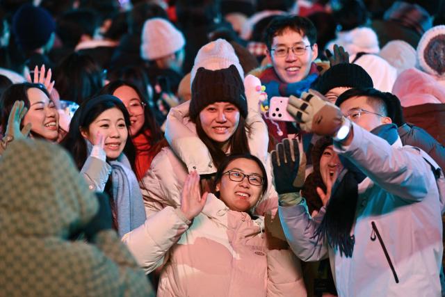 People take selfie photos as they celebrate the New Year 2026 at the Juyongguan Great Wall, Beijing, on January 1, 2026. (Photo by ADEK BERRY / AFP)
