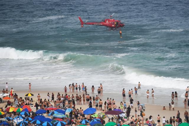 A first responder lifeguard helicopter rescues a diver on the eve of New Year’s celebrations at Copacabana Beach in Rio de Janeiro, Brazil on December 31, 2025. (Photo by Daniel RAMALHO / AFP)