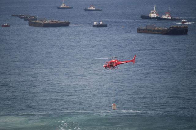 A first responder lifeguard helicopter rescues a diver on the eve of New Year’s celebrations at Copacabana Beach in Rio de Janeiro, Brazil on December 31, 2025. (Photo by Daniel RAMALHO / AFP)
