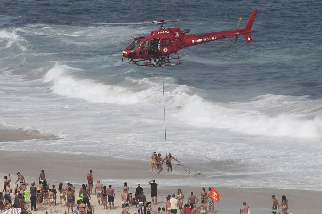 A first responder lifeguard helicopter rescues a diver on the eve of New Year’s celebrations at Copacabana Beach in Rio de Janeiro, Brazil on December 31, 2025. (Photo by Daniel RAMALHO / AFP)