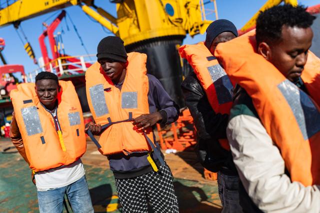 Migrants prepare to board a RHIB (Rigid inflatable boat) as crew members of the “Ocean Viking” rescue ship evacuate them from the oil tanker the 'Maridive 703' in the search-and-rescue zone of the international waters between Malta and Tunisia, on December 31, 2025. 33 migrants were rescued by crew members of the migrants rescue ship "Ocean Viking" operated by the French NGO SOS Mediterranee. They had been stranded on the oil tanker the 'Maridive 703' since their initial rescue 5 days ago in the joint search zone between Malta and Tunisia in international Mediterranean waters. (Photo by Sameer Al-DOUMY / AFP)