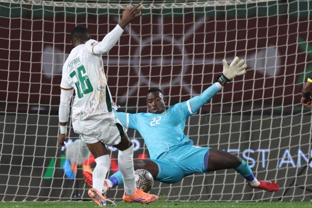 Mozambique's goalkeeper #22 Ivane Urrubal dives to block the ball in front of Cameroon's forward #26 Christian Kofane during the Africa Cup of Nations (CAN) Group F football match between Mozambique and Cameroon at the Grand Stadium in Agadir on December 31, 2025. (Photo by FRANCK FIFE / AFP)