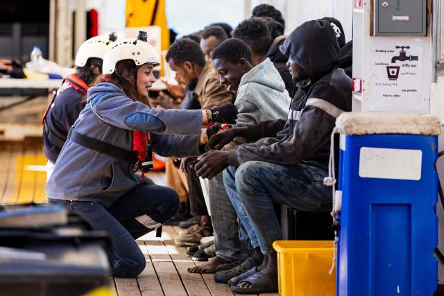 Crew members of the “Ocean Viking” rescue ship distribute bracelets to migrants evacuated by RHIB (Rigid inflatable boat) from the oil tanker the 'Maridive 703' in the search-and-rescue zone of the international waters between Malta and Tunisia, on December 31, 2025. 33 migrants were rescued by crew members of the migrants rescue ship "Ocean Viking" operated by the French NGO SOS Mediterranee. They had been stranded on the oil tanker the 'Maridive 703' since their initial rescue 5 days ago in the joint search zone between Malta and Tunisia in international Mediterranean waters. (Photo by Sameer Al-DOUMY / AFP)