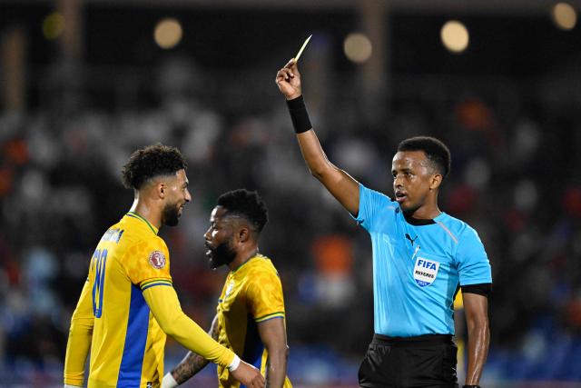 Gabon's forward #20 Denis Bouanga is shown the yellow card by Somali referee Omar Abdulkadir Artan during the Africa Cup of Nations (CAN) Group F football match between Gabon and Ivory Coast at the Grand Stadium in Marrakech on December 31, 2025. (Photo by Khaled DESOUKI / AFP)