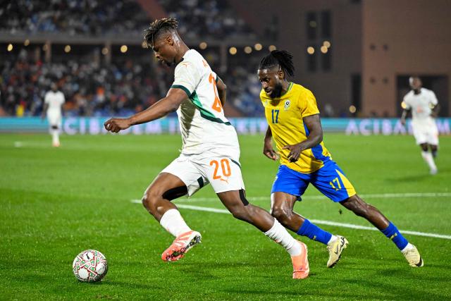 Ivory Coast's defender #20 Emmanuel Agbadou controls the ball in front of Gabon's midfielder #17 Andre Poko during the Africa Cup of Nations (CAN) Group F football match between Gabon and Ivory Coast at the Grand Stadium in Marrakech on December 31, 2025. (Photo by Khaled DESOUKI / AFP)