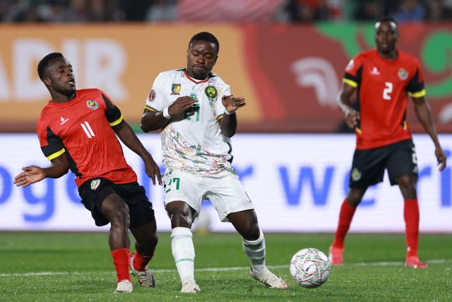 Mozambique's midfielder #11 Joao Bonde (L) fights for the ball with Cameroon's midfielder #27 Arnold Mael Kamdem (2nd L) during the Africa Cup of Nations (CAN) Group F football match between Mozambique and Cameroon at the Grand Stadium in Agadir on December 31, 2025. (Photo by FRANCK FIFE / AFP)