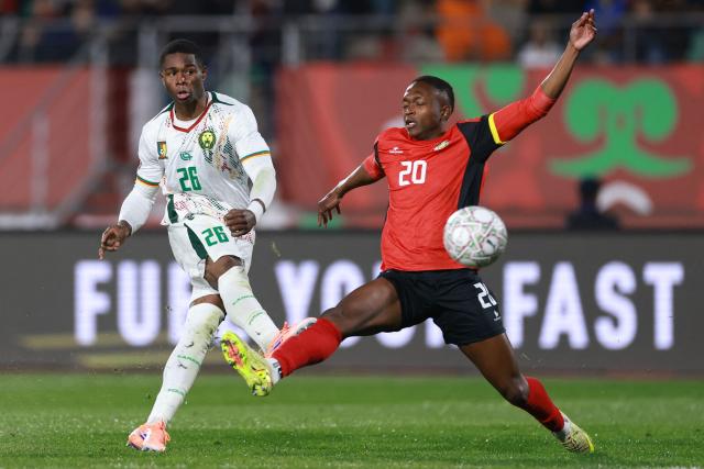 Cameroon's forward #26 Christian Kofane (L) shoots and scores his team second goal despite  Mozambique's midfielder #20 Keyns Abdala (r)during the Africa Cup of Nations (CAN) Group F football match between Mozambique and Cameroon at the Grand Stadium in Agadir on December 31, 2025. (Photo by FRANCK FIFE / AFP)