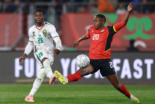 Cameroon's forward #26 Christian Kofane (L) shoots and scores his team second goal despite  Mozambique's midfielder #20 Keyns Abdala (R)during the Africa Cup of Nations (CAN) Group F football match between Mozambique and Cameroon at the Grand Stadium in Agadir on December 31, 2025. (Photo by FRANCK FIFE / AFP)