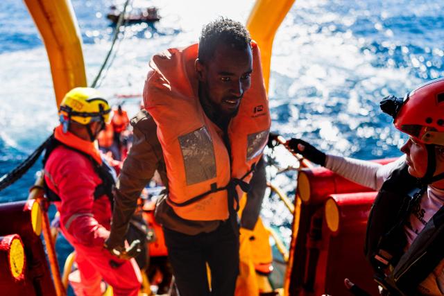 Crew members help a migrant board the “Ocean Viking” rescue ship after being evacuated by RHIB (Rigid inflatable boat) from the oil tanker the 'Maridive 703' in the search-and-rescue zone of the international waters between Malta and Tunisia, on December 31, 2025. 33 migrants were rescued by crew members of the migrants rescue ship "Ocean Viking" operated by the French NGO SOS Mediterranee. They had been stranded on the oil tanker the 'Maridive 703' since their initial rescue 5 days ago in the joint search zone between Malta and Tunisia in international Mediterranean waters. (Photo by Sameer Al-DOUMY / AFP)