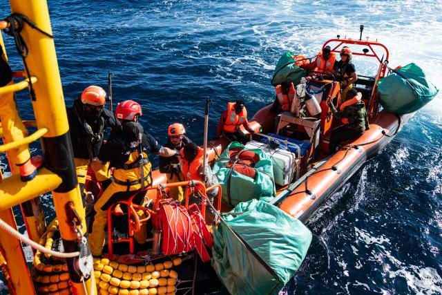Crew members help a migrant board the “Ocean Viking” rescue ship after being evacuated by RHIB (Rigid inflatable boat) from the oil tanker the 'Maridive 703' in the search-and-rescue zone of the international waters between Malta and Tunisia, on December 31, 2025. 33 migrants were rescued by crew members of the migrants rescue ship "Ocean Viking" operated by the French NGO SOS Mediterranee. They had been stranded on the oil tanker the 'Maridive 703' since their initial rescue 5 days ago in the joint search zone between Malta and Tunisia in international Mediterranean waters. (Photo by Sameer Al-DOUMY / AFP)