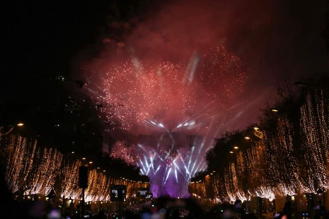 Fireworks explode in the sky over the Arc de Triomphe, on the Place de l'Etoile, in central Paris, to celebrate the New Year, just after midnight on January 1, 2026. (Photo by Alain JOCARD / AFP)