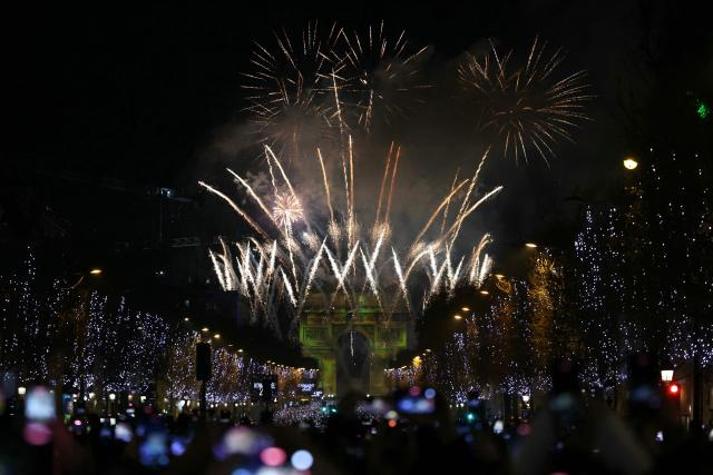 Fireworks explode in the sky over the Arc de Triomphe, on the Place de l'Etoile, in central Paris, to celebrate the New Year, just after midnight on January 1, 2026. (Photo by Alain JOCARD / AFP)