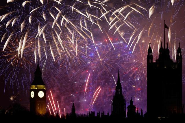 Fireworks explode in the sky to bring in the New Year around the London Eye and the Elizabeth Tower, commonly known by the name of the clock's bell "Big Ben", at the Palace of Westminster, home to the Houses of Parliament, in central London at midnight on January 1, 2026. (Photo by Brook Mitchell / AFP)