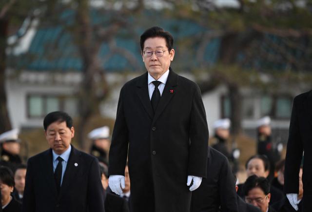 South Korean President Lee Jae Myung walks with his cabinet members as he visits the National Cemetery in Seoul at the beginning of the new year on January 1, 2026. (Photo by Jung Yeon-je / AFP)