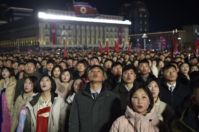People watch a flag-raising ceremony to welcome in the new year at Kim Il Sung Square in Pyongyang on January 1, 2026. (Photo by KIM Won Jin / AFP)