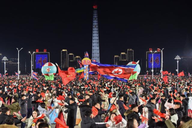 People take part in celebrations to welcome in the new year at Kim Il Sung Square in Pyongyang on December 31, 2025. (Photo by KIM Won Jin / AFP)