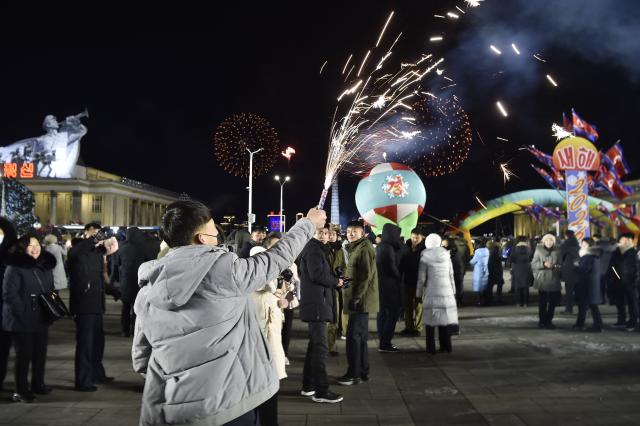 People take part in celebrations to welcome in the new year at Kim Il Sung Square in Pyongyang on January 1, 2026. (Photo by KIM Won Jin / AFP)