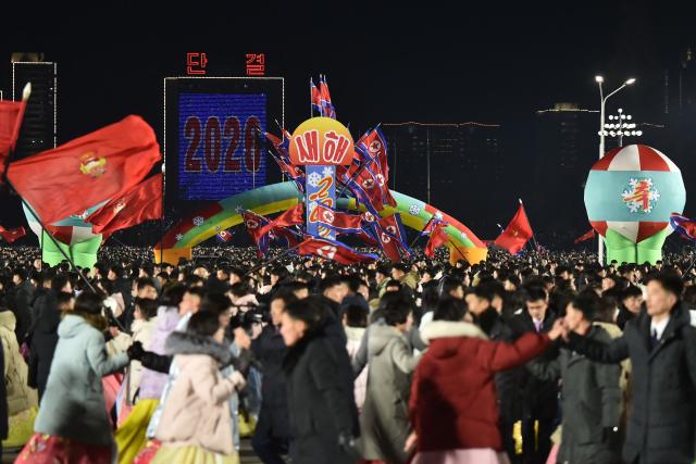 People take part in celebrations to welcome in the new year at Kim Il Sung Square in Pyongyang on December 31, 2025. (Photo by KIM Won Jin / AFP)