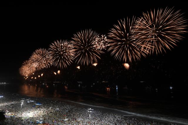 Fireworks to celebrate the New Year explode on Copacabana Beach during celebrations in Rio de Janeiro, Brazil, on January 1, 2026. Rio de Janeiro received, on December 30, 2025, the title of the world’s largest New Year’s Eve celebration from the Guinness World Records, a recognition of its famous massive festivity with live music shows by the sea. (Photo by Daniel RAMALHO / AFP)