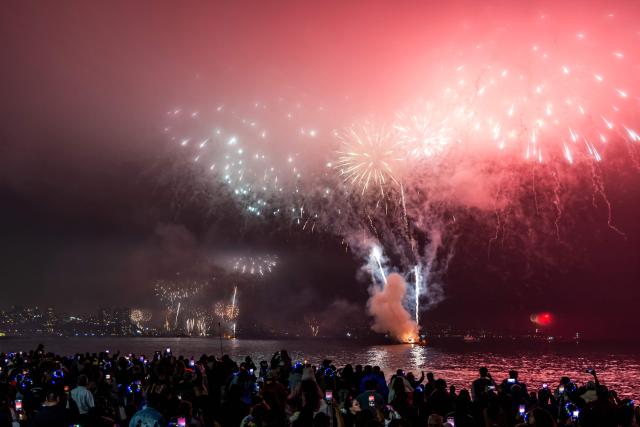 People watch the fireworks explode in the port of Valparaiso on the coast of Chile during New Year celebrations on January 1, 2026. (Photo by Javier TORRES / AFP)