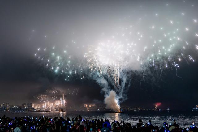People watch the fireworks explode in the port of Valparaiso on the coast of Chile during New Year celebrations on January 1, 2026. (Photo by Javier TORRES / AFP)