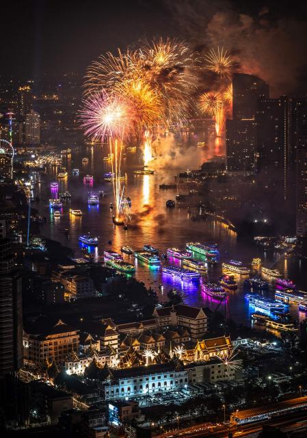 Fireworks light up the midnight sky over the Chao Phraya River during 2026 New Year's Day celebrations in Bangkok on January 1, 2026. (Photo by Chanakarn Laosarakham / AFP)