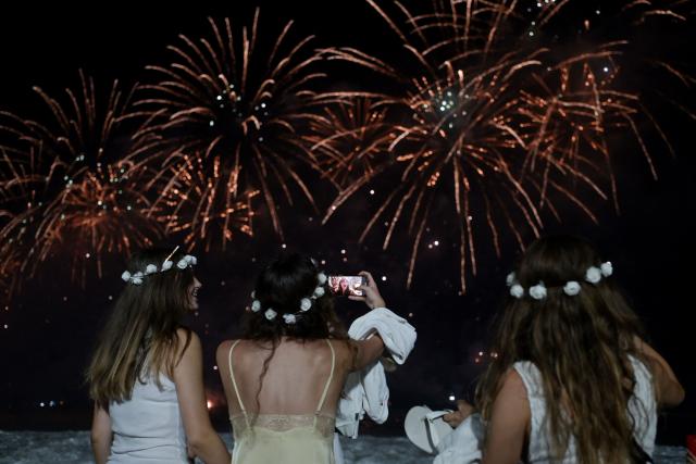 People celebrate as they watch the traditional New Year's fireworks from the water at Copacabana Beach in Rio de Janeiro, Brazil, on January 1, 2026. Rio de Janeiro received, on December 30, 2025, the title of the world’s largest New Year’s Eve celebration from the Guinness World Records, a recognition of its famous massive festivity with live music shows by the sea. (Photo by TERCIO TEIXEIRA / AFP)