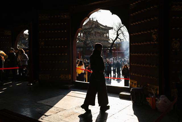 People visit Yonghe Temple, also known as Lama Temple, on the first day of the new year in Beijing on January 1, 2026. (Photo by WANG Zhao / AFP)