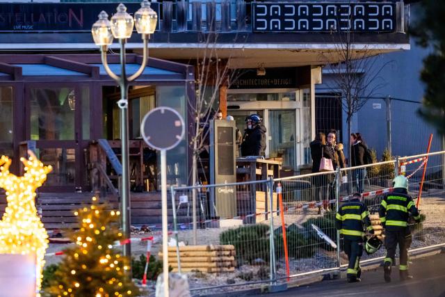 TOPSHOT - Rescuers are seen at the site of an explosion that ripped through a bar in Crans-Montana on January 1, 2026. Several people were killed and others injured when an explosion ripped through a bar in the luxury Alpine ski resort town of Crans Montana, Swiss police said early on January 1. (Photo by MAXIME SCHMID / AFP)