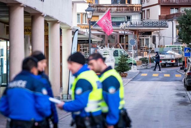 Police officers are seen at the site of an explosion that ripped through a bar in Crans-Montana on January 1, 2026. Several people were killed and others injured when an explosion ripped through a bar in the luxury Alpine ski resort town of Crans Montana, Swiss police said early on January 1. (Photo by MAXIME SCHMID / AFP)