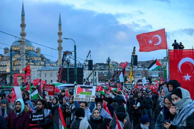 People hold Turkish flags and Palestinain flags as they demonstrate in solidarity with the Palestinian people amid the ongoing war between Israel and the Palestinian Hamas group in the Gaza enclave, at the Galata Bridge in Istanbul on January 1, 2026. (Photo by Yasin AKGUL / AFP)