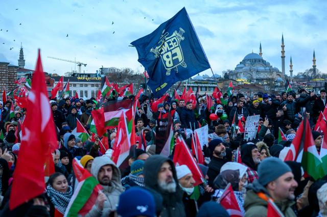 People hold Turkish flags and Palestinain flags as they demonstrate in solidarity with the Palestinian people amid the ongoing war between Israel and the Palestinian Hamas group in the Gaza enclave, at the Galata Bridge in Istanbul on January 1, 2026. (Photo by Yasin AKGUL / AFP)