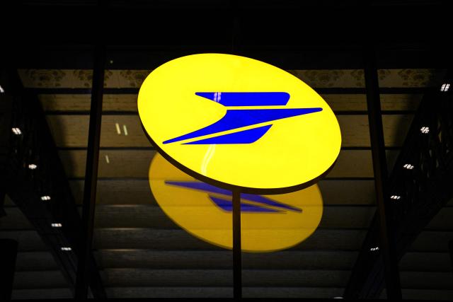 (FILES) A picture taken on January 17, 2022 shows the La Poste logo on a glass facade of La Poste Paris Louvre on the eve of its reopening in Paris. The websites of French mail service La Poste and banking service Banque Postale are difficult to access on January 1, 2026 morning due to a "cyberattack", according to a message on the site, just days after another attack disrupted parcel tracking during the Christmas period. (Photo by Christophe ARCHAMBAULT / AFP)