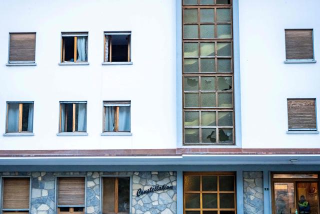 A photograph taken on January 1, 2026 shows broken windows on a building following an explosion that ripped through a bar in Crans-Montana. Several people were killed and others injured when an explosion ripped through a bar in the luxury Alpine ski resort town of Crans Montana, Swiss police said early on January 1. (Photo by MAXIME SCHMID / AFP)