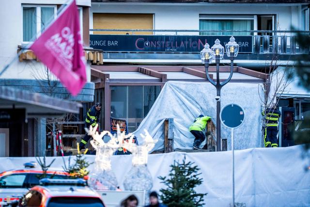 Rescuers and fire-fighters work at the site of an explosion that ripped through a bar in Crans-Montana on January 1, 2026. Several people were killed and others injured when an explosion ripped through a bar in the luxury Alpine ski resort town of Crans Montana, Swiss police said early on January 1. (Photo by MAXIME SCHMID / AFP)