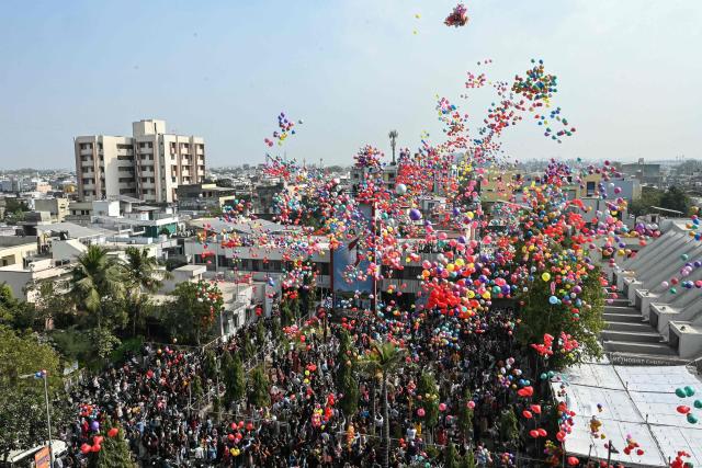People release balloons during New Year celebrations at a church in Ahmedabad on January 1, 2026. (Photo by Shammi MEHRA / AFP)