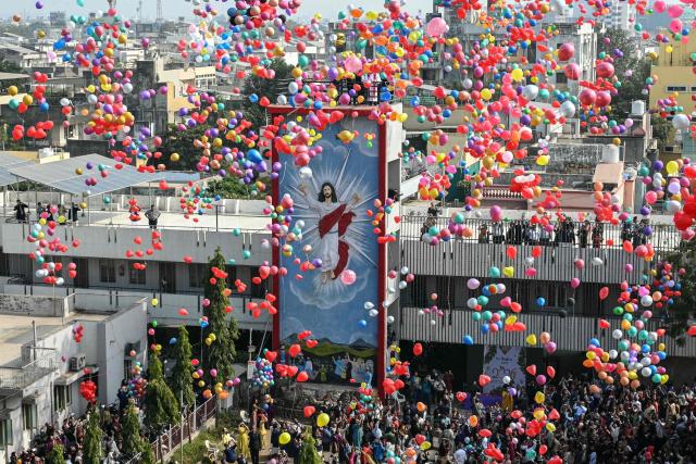 People release balloons during New Year celebrations at a church in Ahmedabad on January 1, 2026. (Photo by Shammi MEHRA / AFP)
