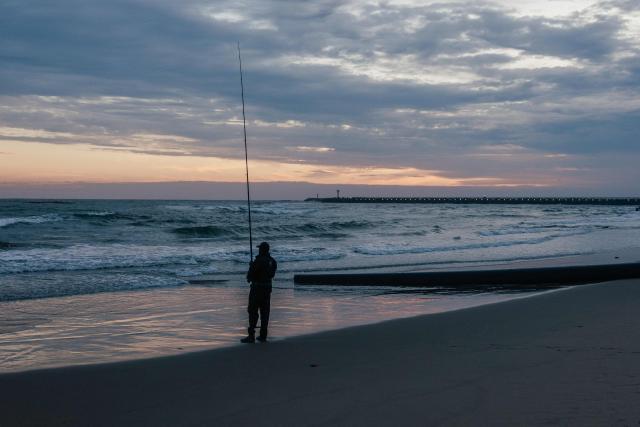 A lone fisherman fishes on New Year's day on the South beach of Durban on January 1, 2026. (Photo by RAJESH JANTILAL / AFP)