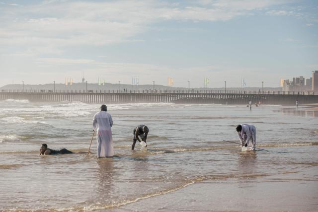 Members of the Zion Christian Church (ZCC) gather sea water at the Durban North beach during New Year’s Day in Durban on January 1, 2026. (Photo by RAJESH JANTILAL / AFP)
