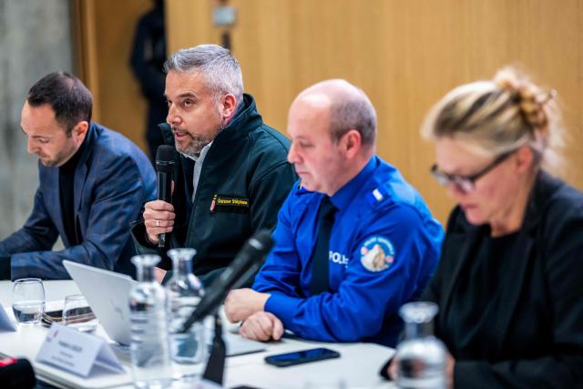 Head of the Department of Security Stephane Ganzer (2nd L) reacts as he speaks during a press conference following an explosion that ripped through the bar Le Constellation in the luxury Alpine ski resort town of Crans-Montana, on January 1, 2026. "Several dozen" people are believed to have died and around 100 were injured when a fire ripped through a crowded bar in the luxury Swiss ski resort town of Crans-Montana, police said January 1. (Photo by MAXIME SCHMID / AFP)