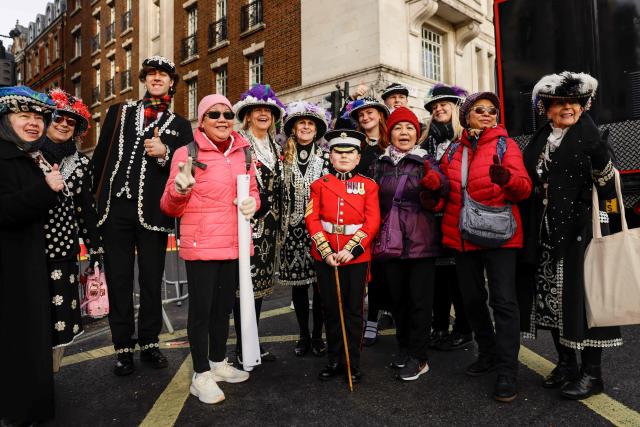 Visitors mix with participants as they pose for a photo ahead of the annual New Year's Day parade, ahead of the start in Green Park in Central London on January 1, 2026. (Photo by Brook Mitchell / AFP)