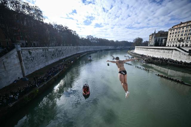 Valerio Schirra dives from the Ponte Cavour, 17 metres above the Tiber, as part of the traditional New Year celebrations on January 1, 2026. (Photo by Filippo MONTEFORTE / AFP)