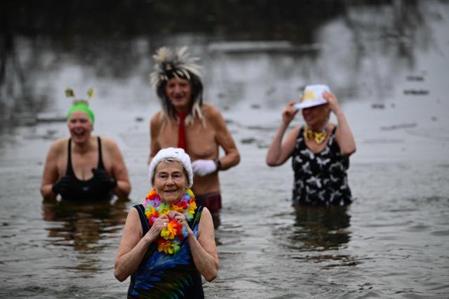 Members of the "Berliner Seehunde" (Berlin Seals) winter swimming club attend the club's traditional New Year swimming event at lake Oranke in Berlin on January 1, 2026. (Photo by Tobias SCHWARZ / AFP)