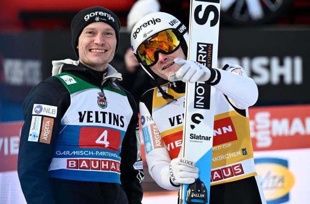 Slovenia's Domen Prevc (R) is congratulated by Slovenia's Anze Lanisek after winning the Men's Individual Large Hill HS142 event of the FIS Ski Jumping World Cup, the second leg of the Four Hills Tournament, in Garmisch-Partenkirchen, southern Germany on January 1, 2026. (Photo by PHILIPP GUELLAND / AFP)