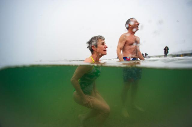 Revelers plunge into the ocean during a snow storm on New Year’s day on January 1, 2026 in Boston, Massachusetts. The polar plunge on New Year's day dates back over 100 years in Boston, but many people, mainly members of the L-Street Brownies, take daily swims 365 days a year into the ocean. (Photo by Joseph Prezioso / AFP)
