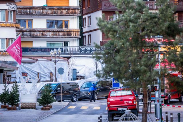 Funeral service vehicles arrive near the bar Le Constellation where a fire ripped through the venue during New Year's Eve celebrations in Crans-Montana, on January 1, 2026. Several dozen people are presumed dead and around 100 injured after a fire ripped through a crowded bar in the luxury Swiss ski resort of Crans-Montana, Swiss police said on January 1, 2026. Police, firefighters and rescuers rushed to the popular resort, which is set to host the Ski World Cup from January 30, after the fire broke out in the early hours of New Year's Day. (Photo by MAXIME SCHMID / AFP)