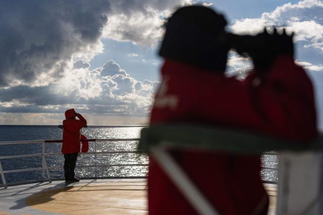 Crew members of the rescue ship "Ocean Viking" operated by the NGO SOS Mediterranee, use binoculars as the ship patrols the search-and-rescue zone of the international waters near Malta, on January 1, 2026. (Photo by Sameer Al-DOUMY / AFP)